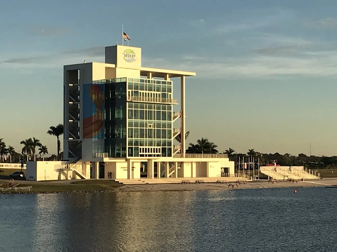 The glass finish tower at Nathan Benderson Park reflected in the rowing lake at sunset